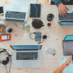 a work desk full of laptops
