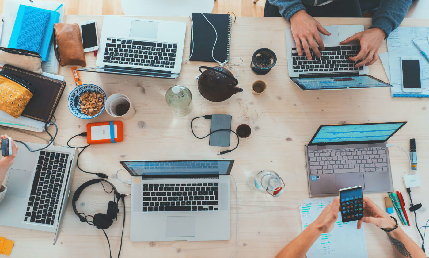 a work desk full of laptops